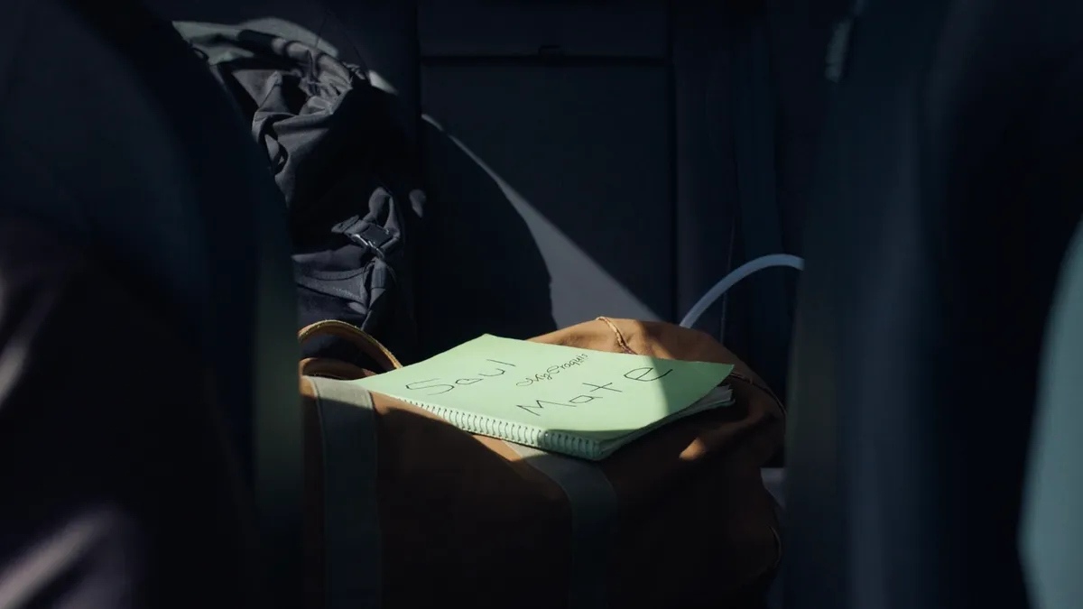 “A notebook reading ‘Soul Mate’ resting inside a dimly lit car.